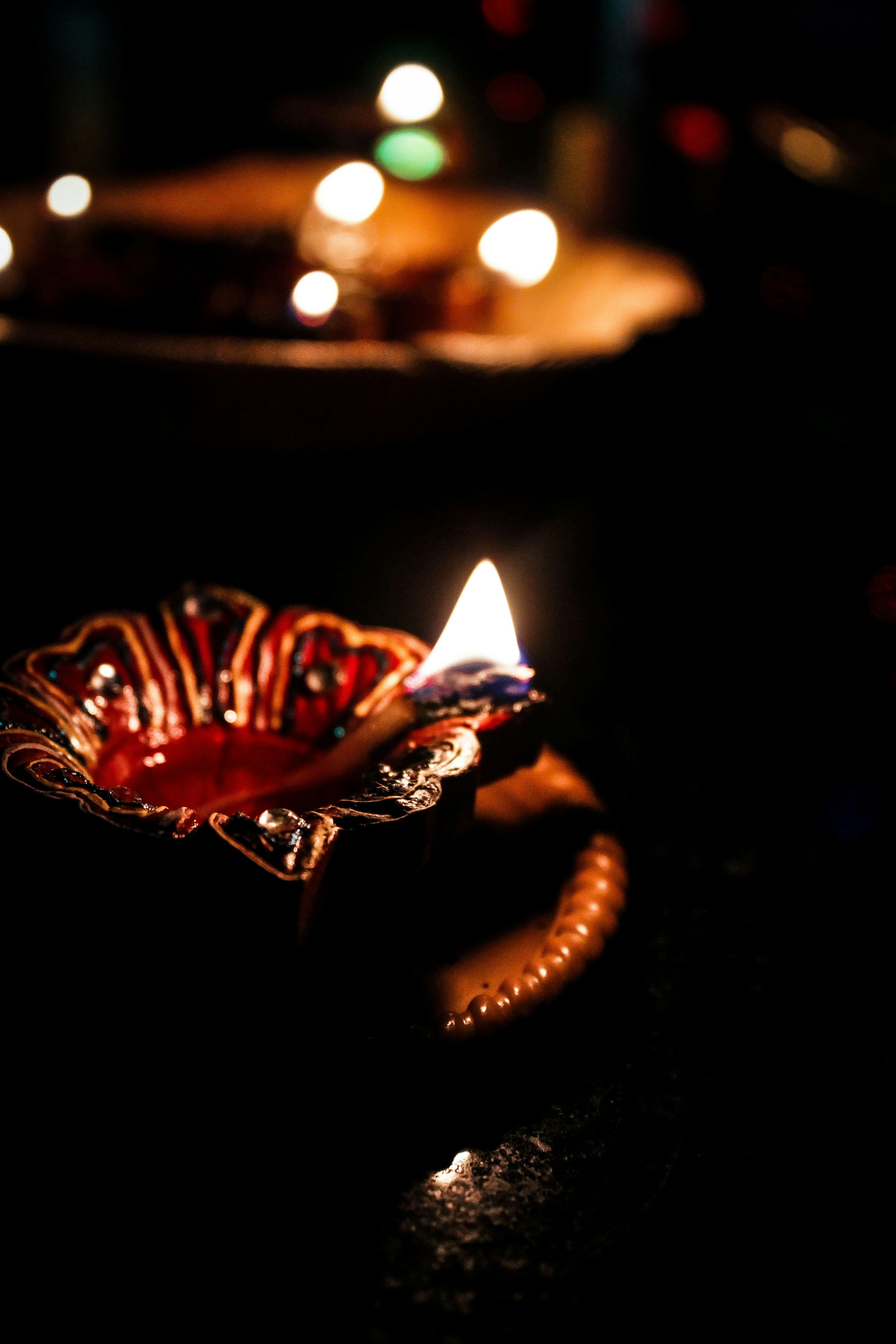 Hands lighting diyas during evening prayer